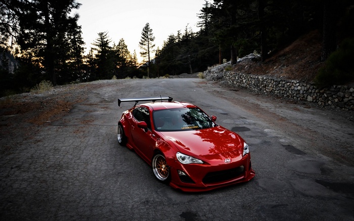 Red Scion FR-S with a large rear spoiler on a mountain road