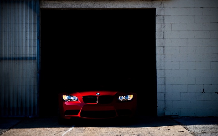 Red BMW car in a dark garage
