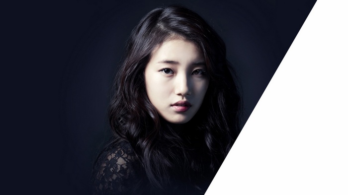 Suzy with black hair wearing a black lace top