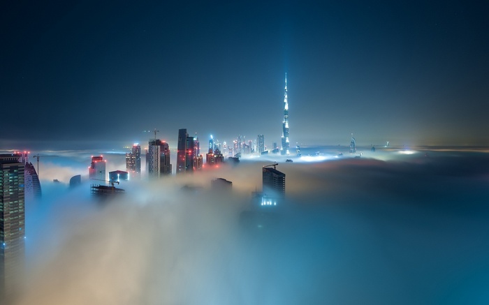 Dubai skyscrapers emerge from fog at night