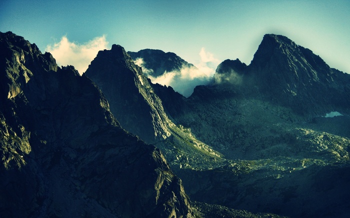 Dark, moody mountain landscape with clouds