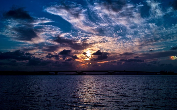 Sunset over the sea with a bridge