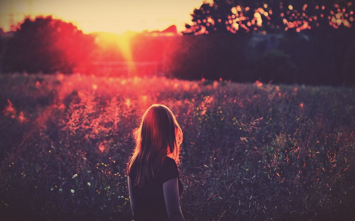 Woman in a field at sunset
