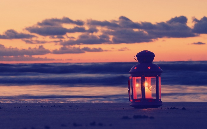 Lantern on a beach at sunset