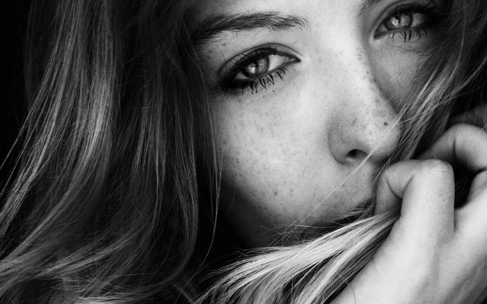 Monochrome close-up of a woman's face with freckles