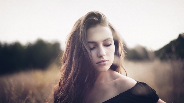 Brunette woman with eyes closed outdoors