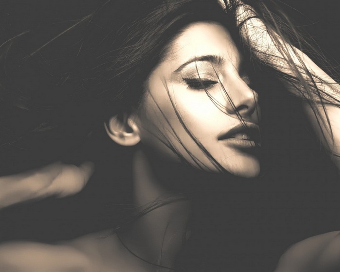 Sepia portrait of a brunette woman with closed eyes