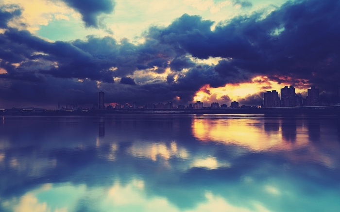 Sunset over a cityscape reflected in water