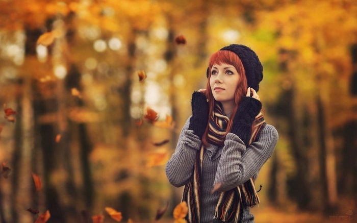 Redhead woman in a black hat and scarf in autumn