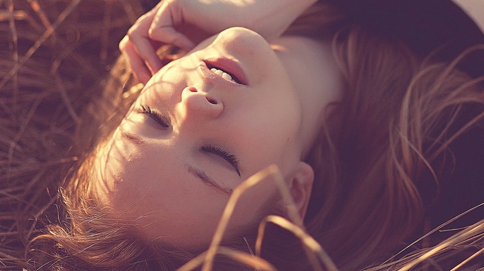 Delaia Gonzalez lying in dry grass with eyes closed