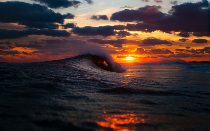 Ocean wave crashing at sunset