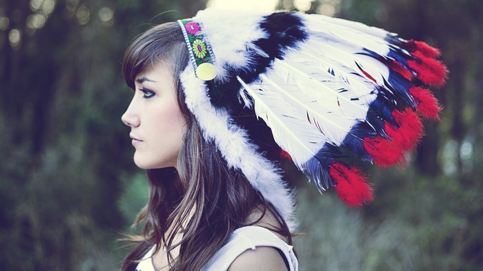 Woman wearing a colorful feathered headdress outdoors