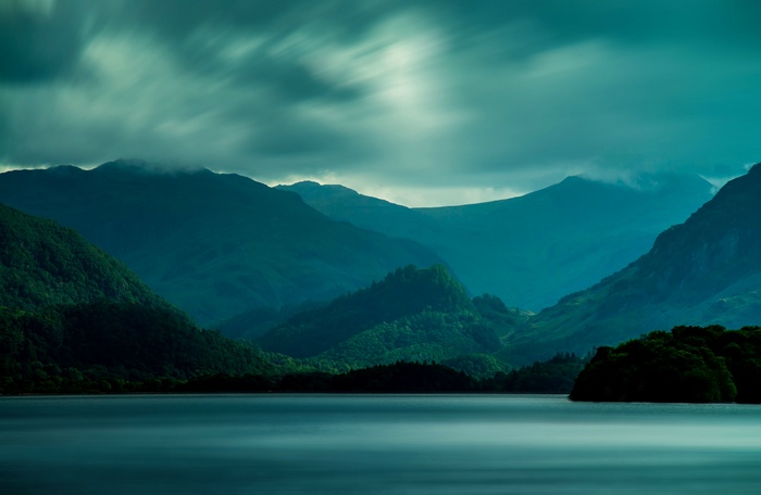 Misty mountains over a calm lake