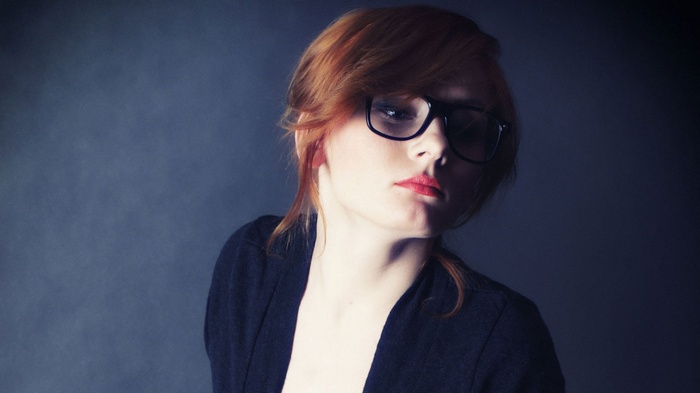 Redhead woman with glasses wearing a black cardigan