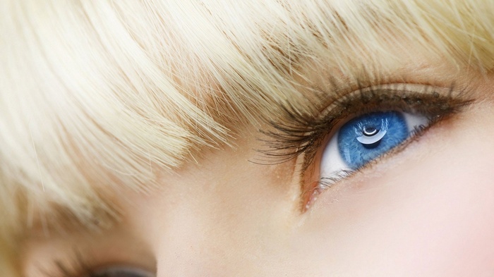 Close-up of a woman's blue eye and blonde hair
