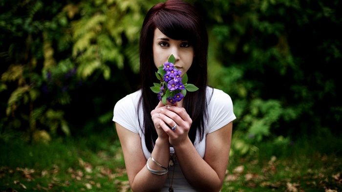 Woman holding purple flowers outdoors