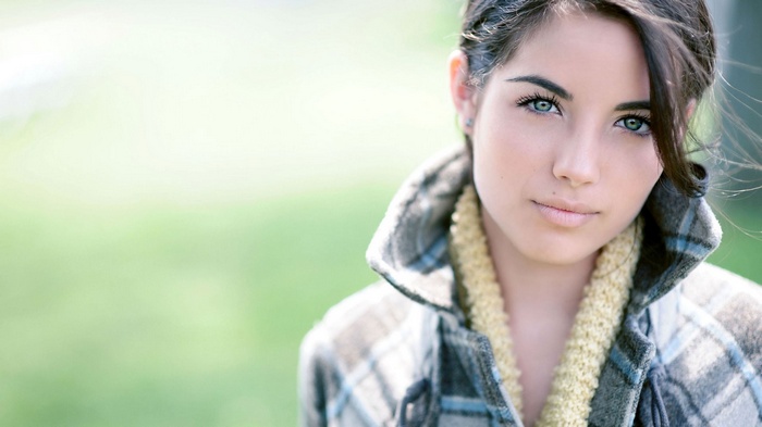 Woman with blue eyes wearing a plaid coat