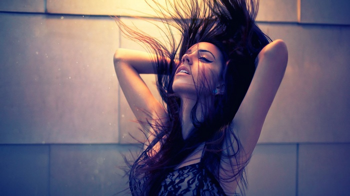 Woman with hair flying and arms up