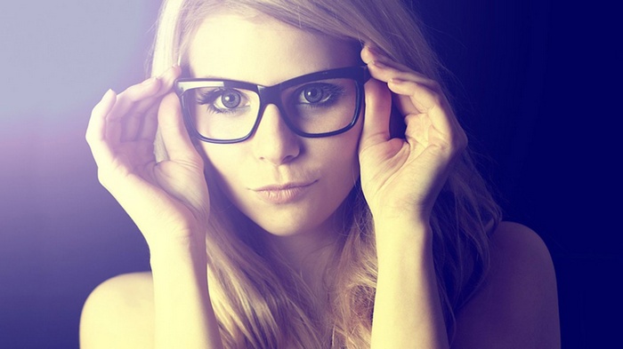 Woman with glasses adjusting her eyewear