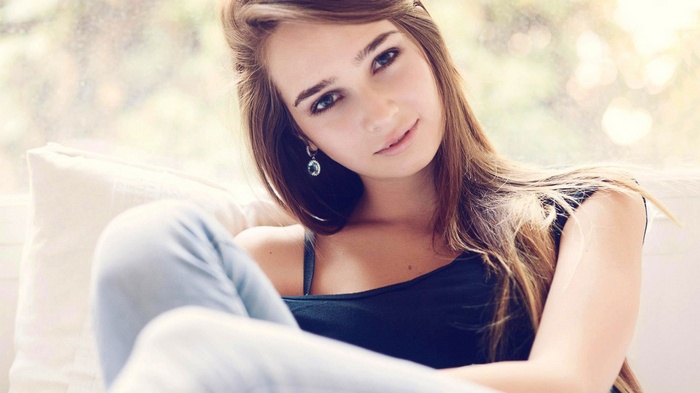 Young woman with long brown hair wearing a dark top
