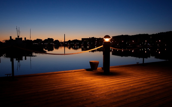Harbor at sunset with wooden pier and lights