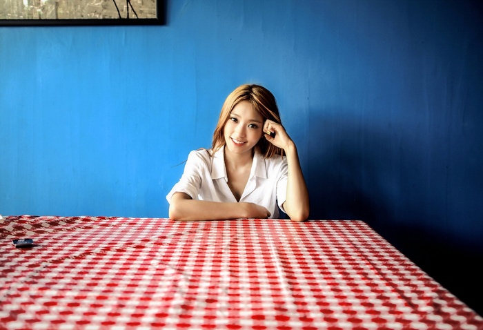 Yoon Bora sits at a table with a red and white checkered tablecloth