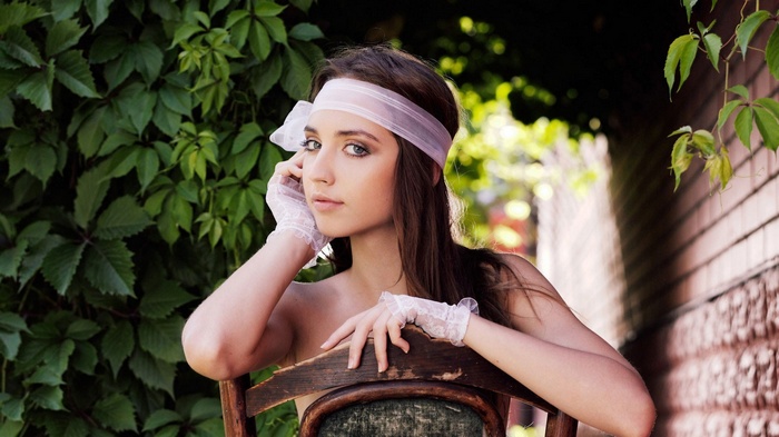Woman with gloves and headband sitting on a chair