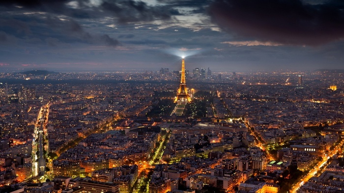 Eiffel Tower illuminated at night over Paris cityscape