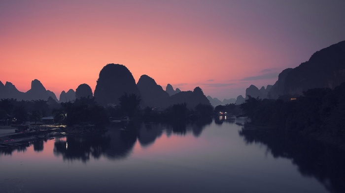 Karst mountains at sunset reflected in a river