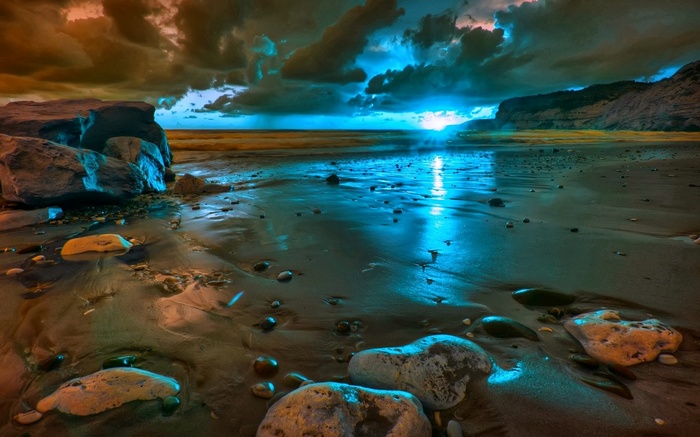 Beach with rocks and sea under dramatic sky
