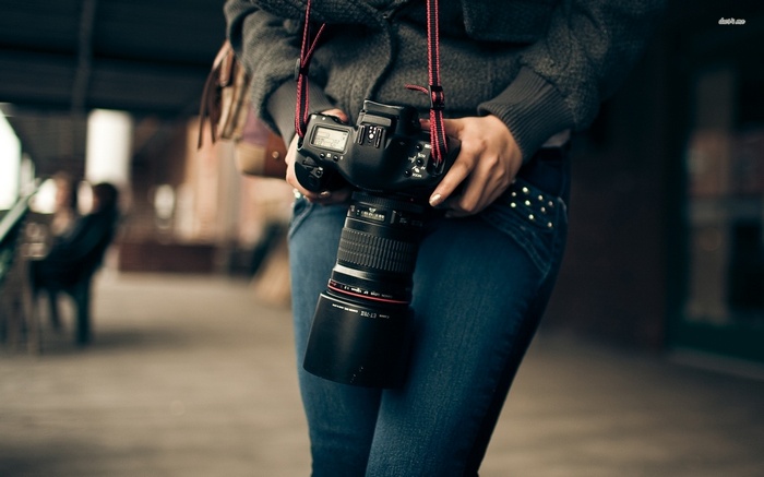 Woman holding a Canon DSLR camera