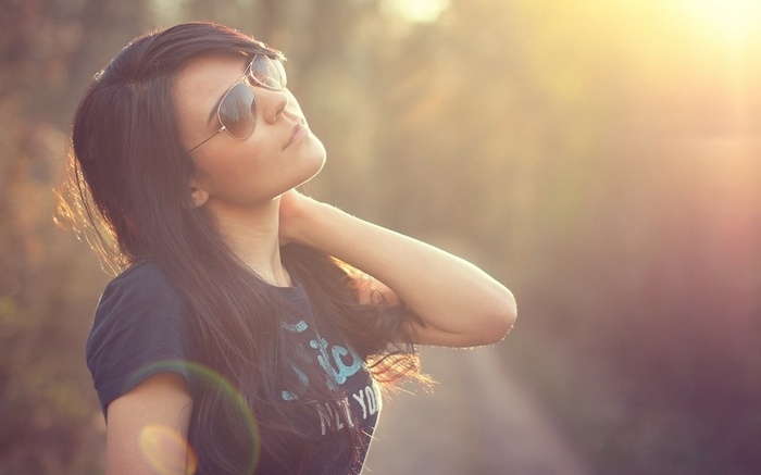 Woman wearing sunglasses outdoors in sunlight
