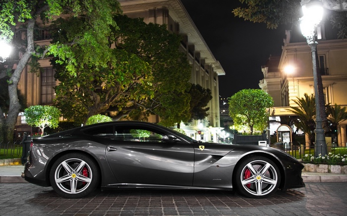 Ferrari F12 parked at night in front of a building