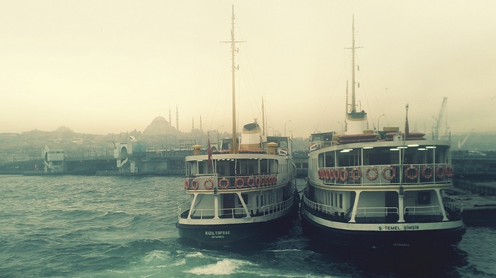 Two ferries docked in Istanbul with mosques in the background