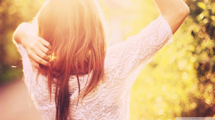 Woman with arms up in sunlight