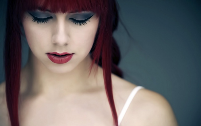 Redhead woman with red lipstick and closed eyes