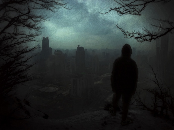Silhouette of a person overlooking a dark city at night