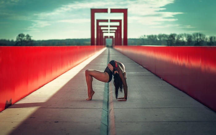 Woman performing gymnastics on a bridge