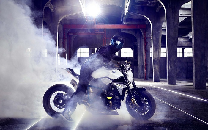 BMW motorcycle doing a burnout in a warehouse