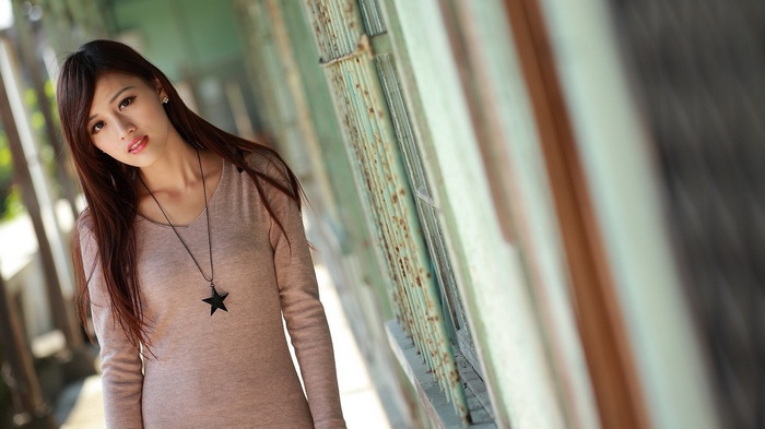 Asian woman with long brown hair and star necklace