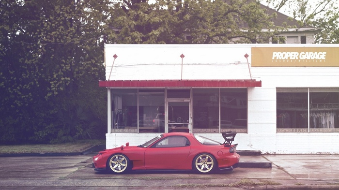 Red Mazda RX-7 parked in front of Proper Garage