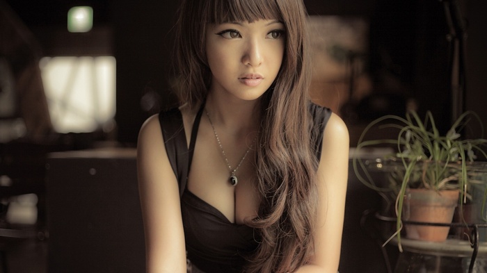 Asian woman with long brown hair wearing a necklace