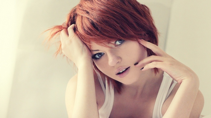 Redhead woman with hands in hair, painted nails
