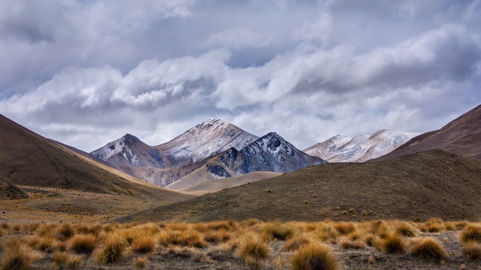 Snow-capped mountains under a cloudy sky