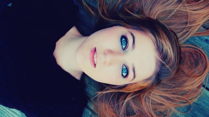 Woman with striking blue eyes lying down