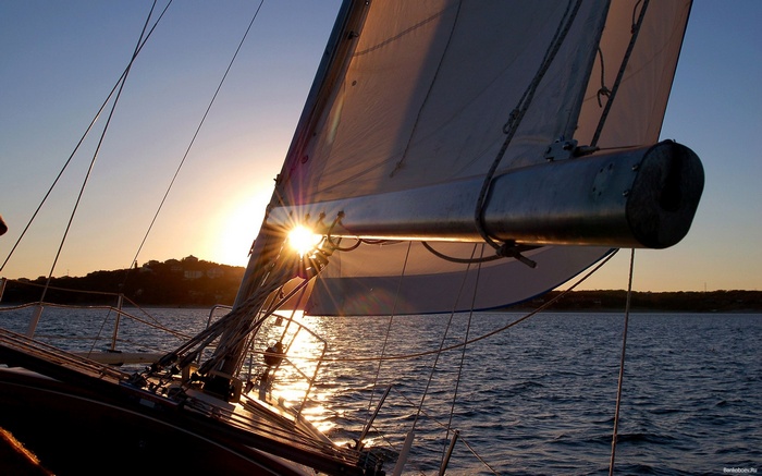 Sailboat sailing at sunset over the sea