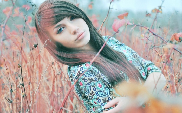 Young woman with long brown hair in a field