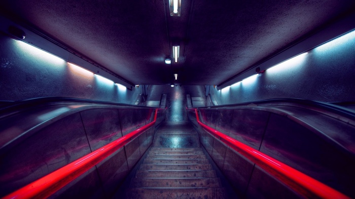 Escalator and stairs with red handrails