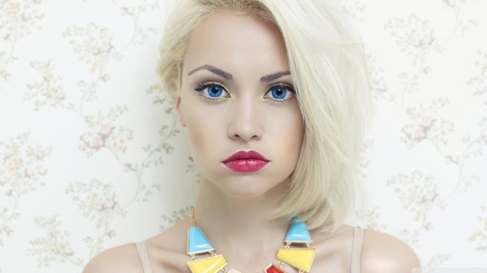 Blonde woman with blue eyes and colorful necklace