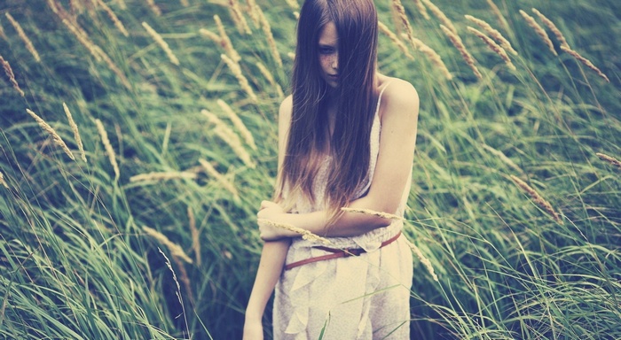 Woman with long hair in a field of tall grass